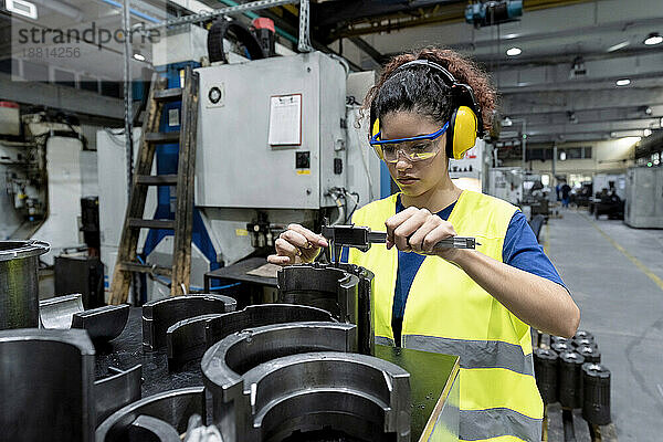 Wartungsingenieur in Arbeitsschutzkleidung führt Qualitätskontrolle in einer modernen Fabrik durch