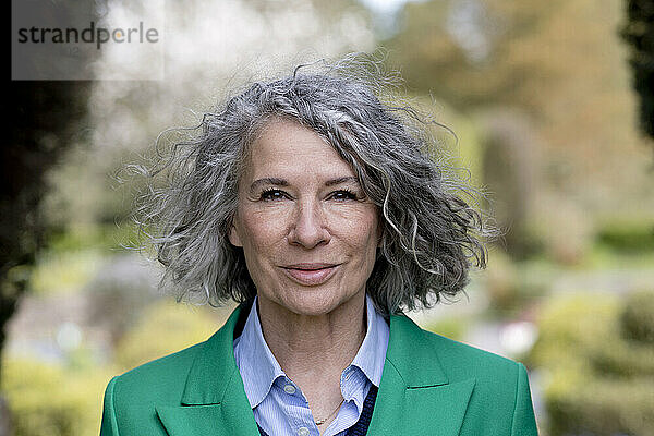 Lächelnde ältere Frau mit grauem lockigem Haar  Porträt
