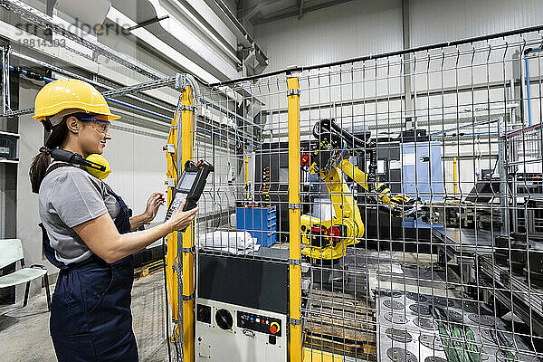 Ingenieur bedient Roboterarm in moderner Fabrik