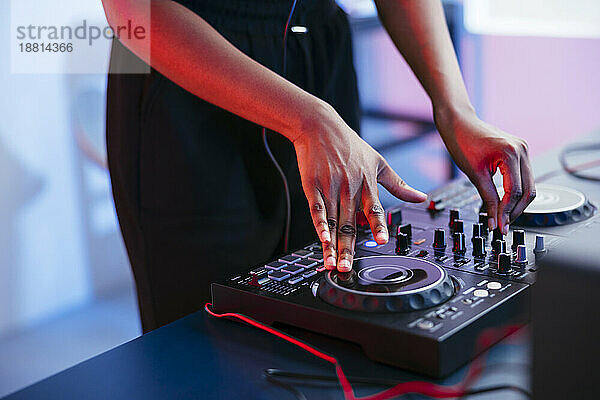 Weibliche DJ bedient Soundmixer zu Hause