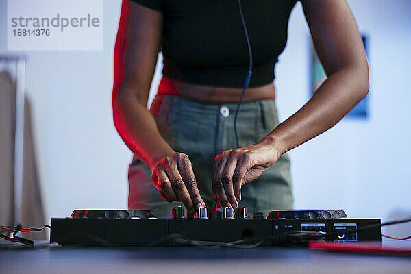 Junge DJ-Frau bedient zu Hause den Soundmixer