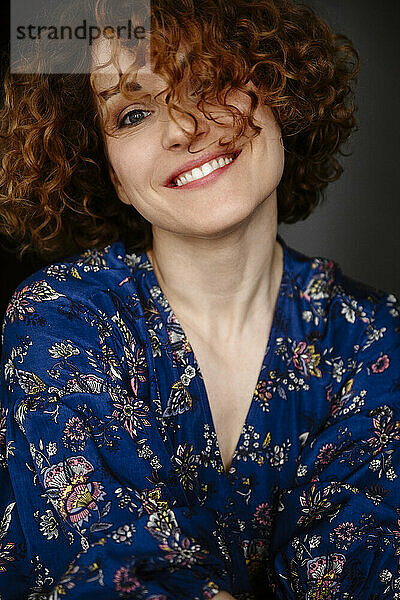 Happy woman with curly hair wearing floral dress