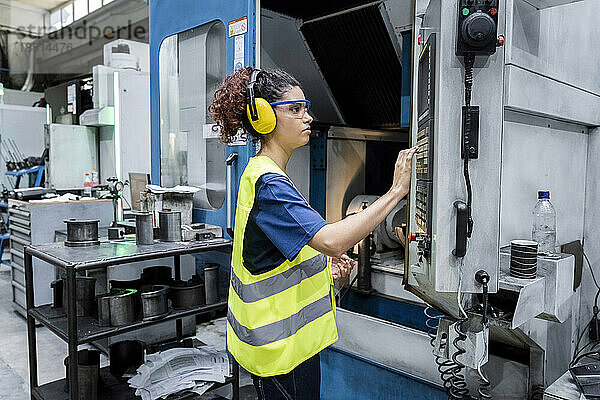 Wartungsingenieur bedient CNC-Maschine in moderner Fabrik