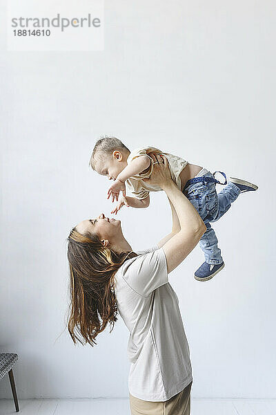 Mother playing with son in front of white backdrop