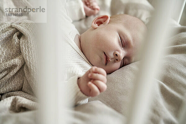 Kleines Mädchen mit geschlossenen Augen schläft im Kinderbett