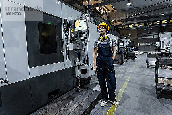 Wartungsingenieur steht an der CNC-Maschine in einer modernen Fabrik