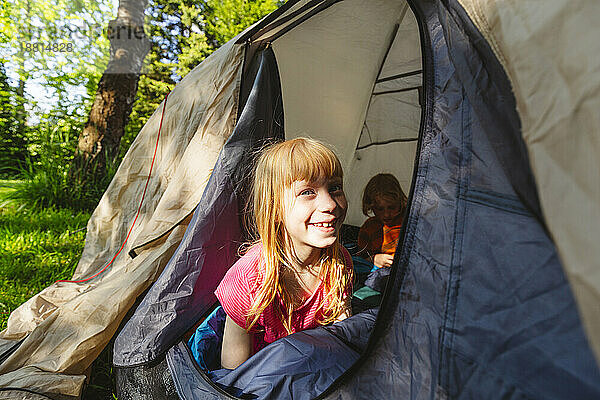 Glückliches erdbeerblondes Mädchen  das Camping genießt