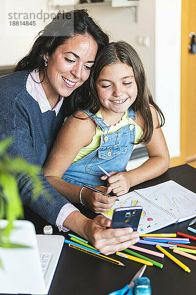 Mother taking selfie with daughter homeschooling at home