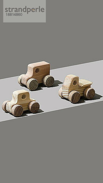 Spielzeugautos aus Holz auf grauem Hintergrund