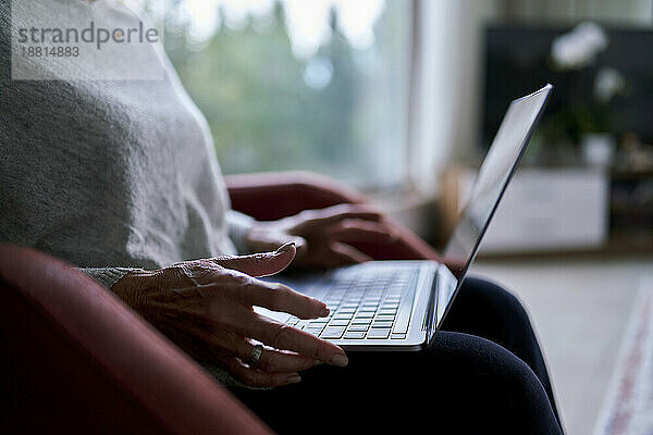 Ältere Frau benutzt Laptop zu Hause
