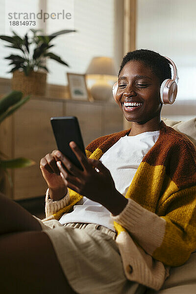 Happy young woman watching movie on smart phone