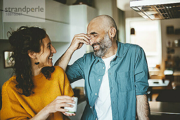 Happy man with woman having coffee at home