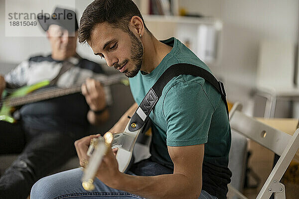 Musicians with electric guitars practicing at home