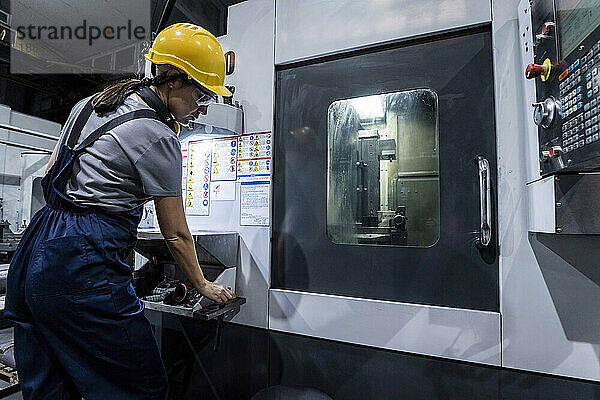 Wartungsingenieur arbeitet an einer CNC-Maschine in einer modernen Fabrik