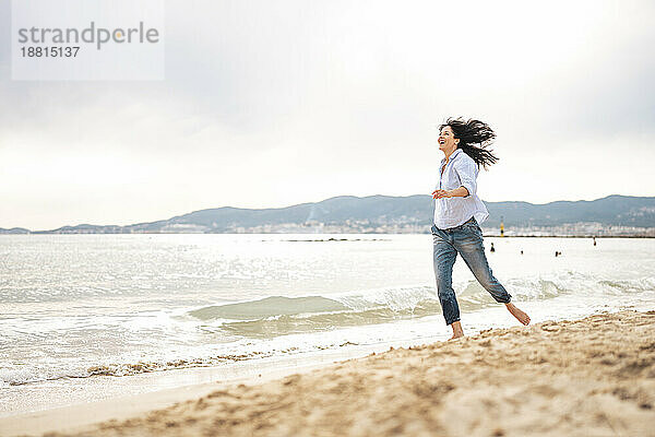 Verspielte Frau verbringt Urlaub am Meer am Strand