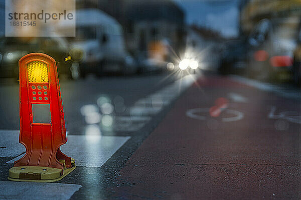 Straßenreflektor vor dem Radweg in der Abenddämmerung