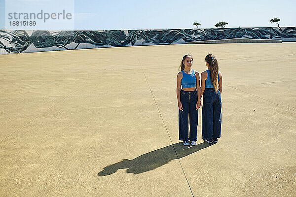 Sisters standing together in skateboard park