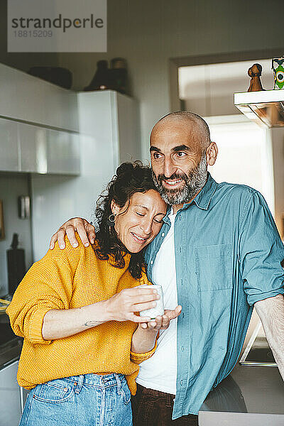 Glücklicher Mann und Frau  die zu Hause eine Kaffeetasse halten