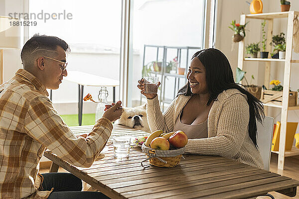 Young couple enjoying breakfast at dining table