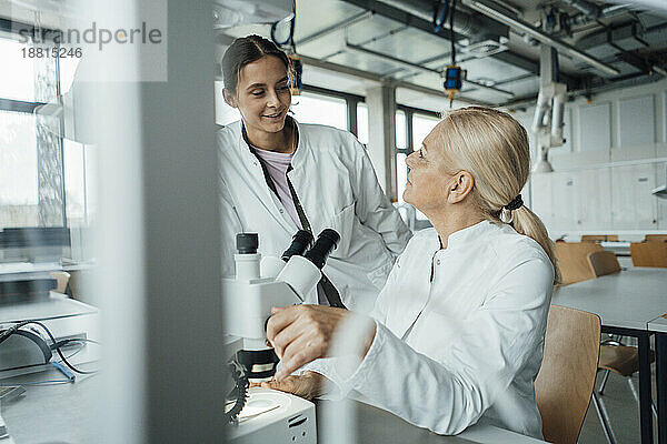 Lächelnder Wissenschaftler diskutiert mit Kollegen im Labor