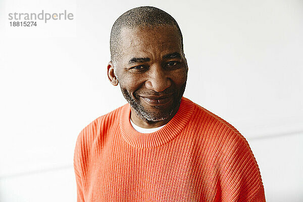 Smiling mature man wearing orange sweater