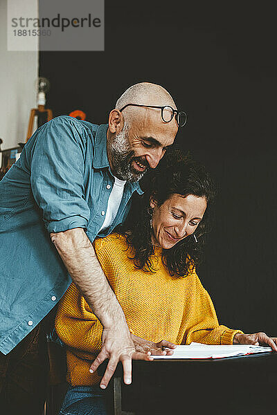 Lächelnder Mann und Frau bereiten zu Hause Finanzrechnungen vor