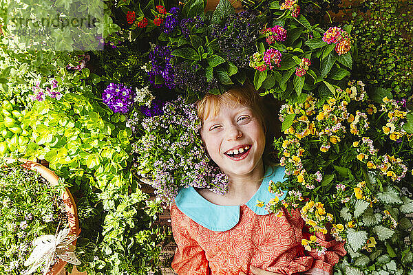 Happy girl lying amidst flowering plants