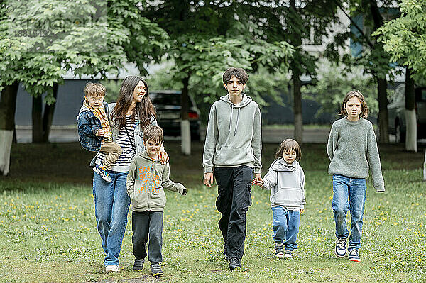 Glückliche Mutter geht mit Kindern im Park spazieren