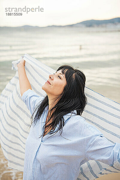 Sorglose Frau mit Schal am Strand