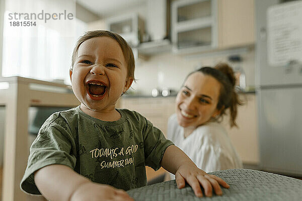 Fröhliches Mädchen lacht mit Mutter in der Küche
