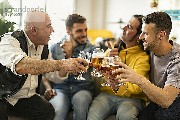 Fröhliche Freunde  die zu Hause gemeinsam Bier anstoßen