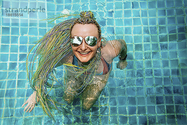 Glückliche Frau genießt und schwimmt im Pool