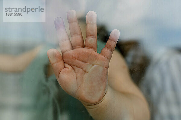 Baby girl palm on glass window