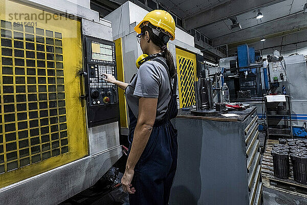 Wartungstechniker bedient die CNC-Maschinentastatur in einer modernen Fabrik