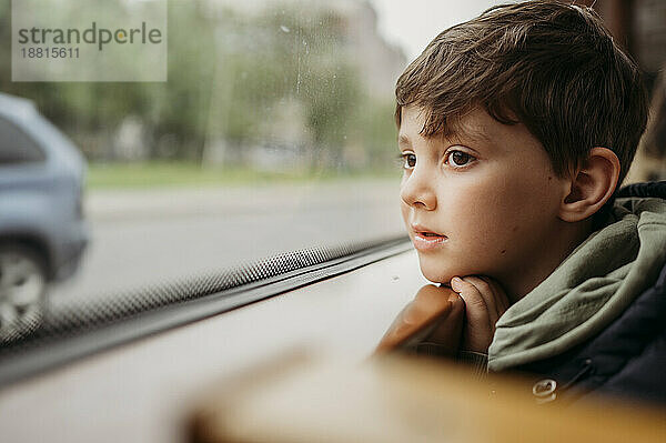 Boy traveling by tram sitting near window