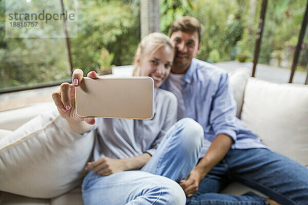 Glückliches Paar  das zu Hause ein Selfie mit dem Smartphone macht