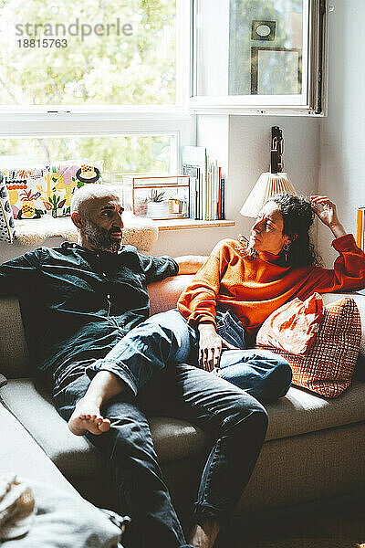 Man and woman relaxing on sofa at home