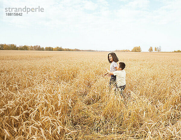Brother and sister playing in wheat farm