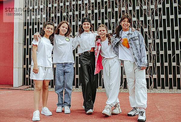 Teenager-Mädchen stehen mit Armen vor der Mauer auf dem Spielplatz