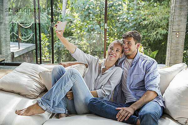 Glückliche Frau  die zu Hause ein Selfie mit einem Mann macht