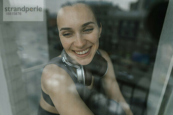 Happy woman looking from glass window