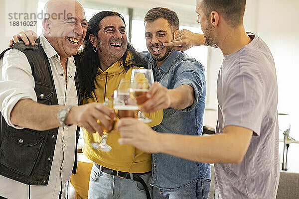 Glückliche Freunde  die zu Hause mit Biergläsern feiern