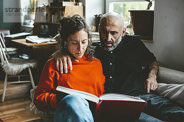 Mann und Frau lesen zu Hause ein Buch