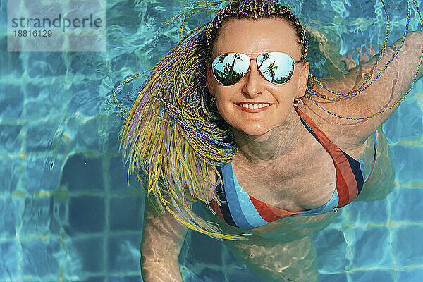 Glückliche Frau genießt und schwimmt im Pool