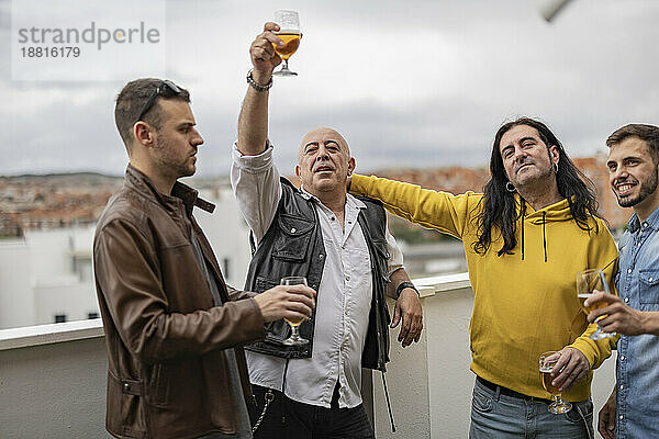 Fröhliche Freunde  die gemeinsam Bier auf dem Dach genießen