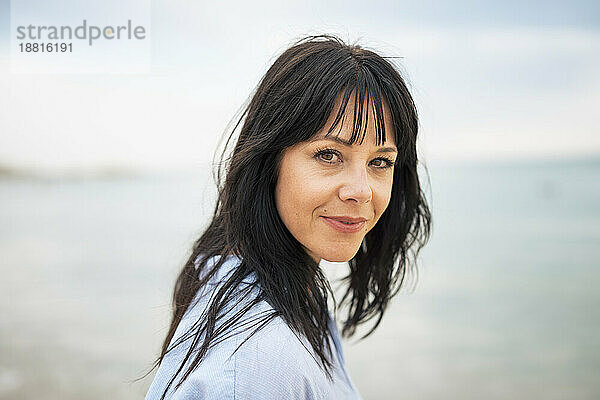 Reife Frau mit Pony am Strand