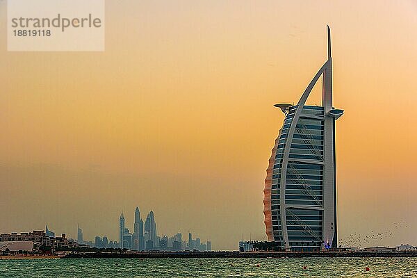 DUBAI  VEREINIGTE ARABISCHE EMIRATE 11. FEB 2019: Der Burj Al Arab oder Turm der Araber  ein Luxushotel in Dubai mit den Marina Towers im Hintergrund  Vereinigte Arabische Emirate  Asien