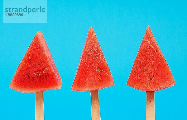 Drei Wassermelone Pops auf einem blaün Hintergrund  Erfrischung oder gesunde Ernährung Lebensmittelkonzept