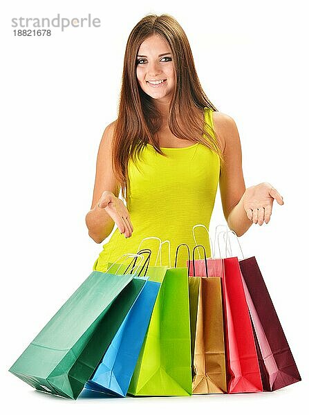 Junge glückliche Frau mit bunten Papier Einkaufstaschen vor weißem Hintergrund