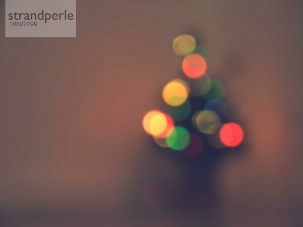 Blurred Weihnachtsbaum mit bunten Lichtern in einem dunklen Raum saisonalen Hintergrund mit Platz für Text